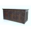 A 19th century oak chest, with lift lid and three panel carved front, 119 by 49.5 by 54cm high.