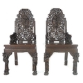 A pair of Chinese hardwood chairs, possibly huanghuali, profusely carved with birds, flowers, figure... 