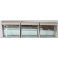 A group of three wall mounted display cabinets, with mirror backs, single glazed doors, and glass sh... 