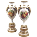 A pair of large modern Royal Worcester pedestal vases, foliate clasped twin handles, decorated in a ... 