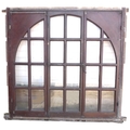 A pair of arched architectural windows of grand scale with brass fittings, each with twenty four gla... 