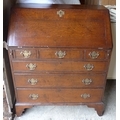 A George III oak bureau, fall front with fitted interior, three over three drawers with brass plate ... 
