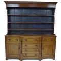 An early 19th century mahogany Welsh dresser, wide cornice over a three shelf plate rack with the ba... 
