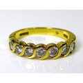 An 18ct gold and diamond half eternity ring in guilloche setting of seven stones, approximately 0.5c... 