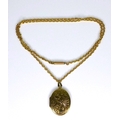 A 15ct gold chain with 9ct gold foliate engraved oval locket, locket 5.6g, chain 10.4g.