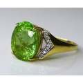 An 18ct gold green tourmaline and diamond ring,  the central lime green oval cut tourmaline approx 6... 