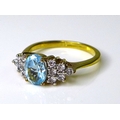 An aquamarine dress ring, the oval central stone flanked by a cluster of six white stones to either ... 