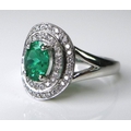 An 18ct white gold, emerald and diamond ring, the central oval cut emerald of approximately 0.75ct e... 