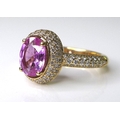 An 18ct rose gold, pink sapphire and diamond ring, the central oval cut sapphire of 1.35ct, set to s... 
