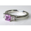 A platinum, pink sapphire and diamond ring, the central emerald cut sapphire of approximately 0.6ct ... 