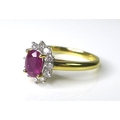 An 18ct yellow gold, ruby and diamond ring, the central oval cut ruby of approximately 0.9ct surroun... 