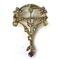An Edwardian Art Nouveau suffragette brooch set with seed pearls, peridot and amethyst, 4 by 2.8cm.