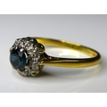 An 18ct yellow gold, sapphire and diamond flowerhead ring, the central stone surrounded by eight dia... 
