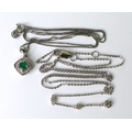 An 18ct white gold, emerald and diamond necklace, the diamond shaped pendant set with a central emer... 