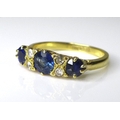 An 18ct yellow gold sapphire and diamond ring, the central stone approximately 0.6ct, flanked by fou... 