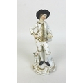 An early 19th century porcelain figure, possibly Derby, modelled as a gentleman standing with his le... 