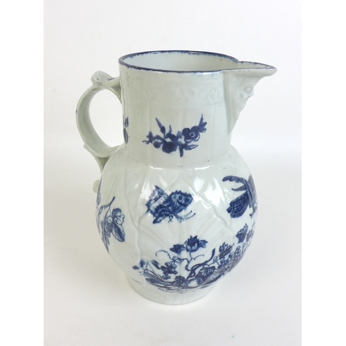 25 - A group of five face mask jugs, comprising three blue and white decorated with sprays of flowers, Sa... 