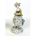 A late 18th century soft paste porcelain figure of a lady, possibly Chelsea-Derby, modelled standing... 