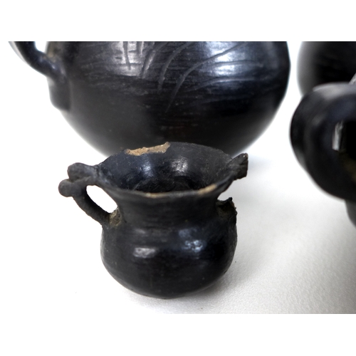 65 - Five pieces of Chinese Longshan style black pottery, comprising two twin handled tea bowls, two sing... 