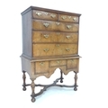 An early Georgian walnut chest on stand, an arrangement of drawers with brass plate handles, the bas... 