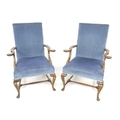 A pair of mid 20th century mahogany open armchairs, with out scrolled arms, upholstered in blue velv... 