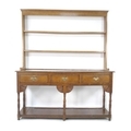 A George III oak dresser base, three frieze drawers with brass swan neck handles, floor level pot sh... 