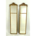 A pair of Edwardian small narrow wall mirrors, each with two part plates set in gilt moulded frames ... 