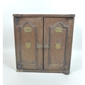 A late Victorian smoker's cabinet, in the form of a safe with brass plaques to the twin doors, one e... 