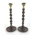 A pair of 19th century oak candlesticks, each with barley twist columns, cast brass drip trays with ... 