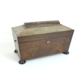 A Regency rosewood tea caddy, of sarcophagus form, the lift lid opening to reveal two lift out domed... 