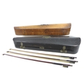 Two 19th century wooden violin coffin cases, and three violin bows, one stamped 'Voisin', the walnut... 