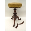 A 19th century rosewood piano stool, with upholstered revolving seat, with carved column and tripod ... 