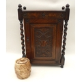 A 1930s oak tobacco cabinet with tobacco jar, cabinet with barley twist columns to each corner and a... 