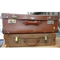 A group of two vintage suitcases, comprising a brown leather case and a slightly smaller case with l... 