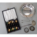 A group of silver and plated wares, including a cased set of silver coffee spoons, two silver napkin... 