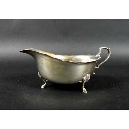 18 - A pair of George VI silver sauce boats, each raised on three hoof feet and with C scroll handles, Wa... 