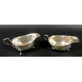 A pair of George VI silver sauce boats, each raised on three hoof feet and with C scroll handles, Wa... 