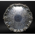 A Victorian silver salver tray, of circular Rococo form with Chippendale pie crust and C scroll rim,... 