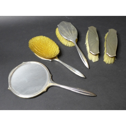 21 - An Art Deco silver backed dressing table set, decorated in an engine turned sunburst guilloche desig... 