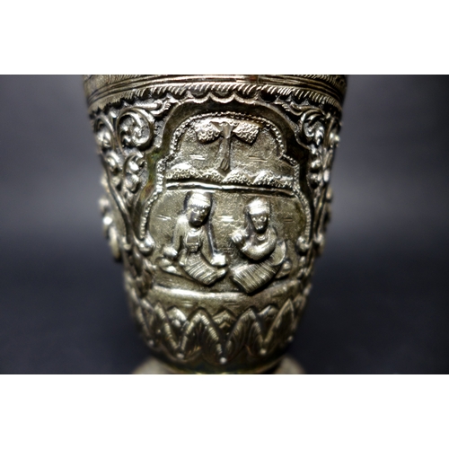 32 - A group of silver and plated items comprising a Burmese silver beaker with chased and repousse panel... 