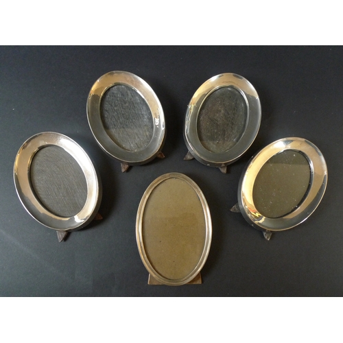 46 - A group of five silver oval photograph frames, comprising a set of four frames, each 14cm oval, Char... 