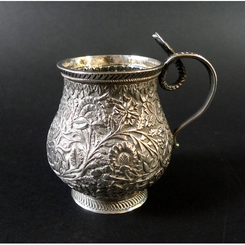 45 - An Indian white metal cup, of baluster form, intricately decorated with flowers and foliage, with a ... 