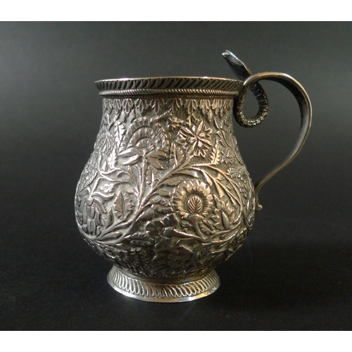 45 - An Indian white metal cup, of baluster form, intricately decorated with flowers and foliage, with a ... 