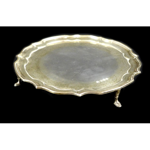 60 - An Elizabeth II silver waiter tray, of circular form with Chippendale pie crust edge, raised on four... 