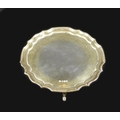 An Elizabeth II silver waiter tray, of circular form with Chippendale pie crust edge, raised on four... 