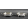 A pair of silver George V twin handled oval form planished bowls, with presentation inscription to '... 