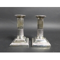 A pair of late Victorian silver dwarf candlesticks, of Roman Doric column form, with square plinths,... 