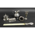 A group of five silver items, comprising a Victorian milk jug with repousse decoration and C shaped ... 