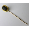 A yellow metal stick pin inset with a ceramic scarab beetle, tests as 22ct gold, 8cm long, 3.8g, wit... 