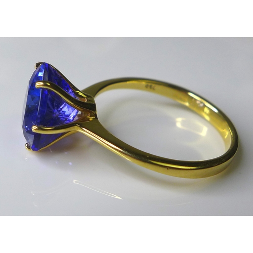 307 - An 18ct gold and AAA tanzanite ring, the deep violet trilliant cut stone of approximately 3.3ct, 9 b... 